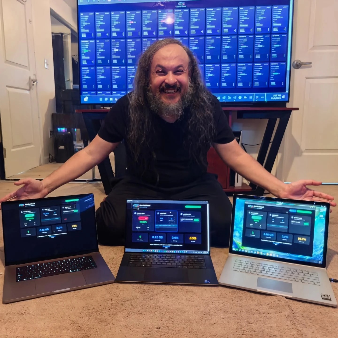 Three laptops, one wall of dashboards — PeerLLM hosts humming in the living room.